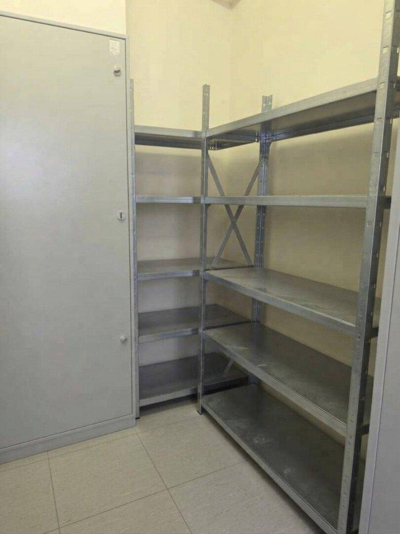 Lagerraum mit Metallregalen und einem grauen Schrank, ideal für die Organisation von Vorräten.