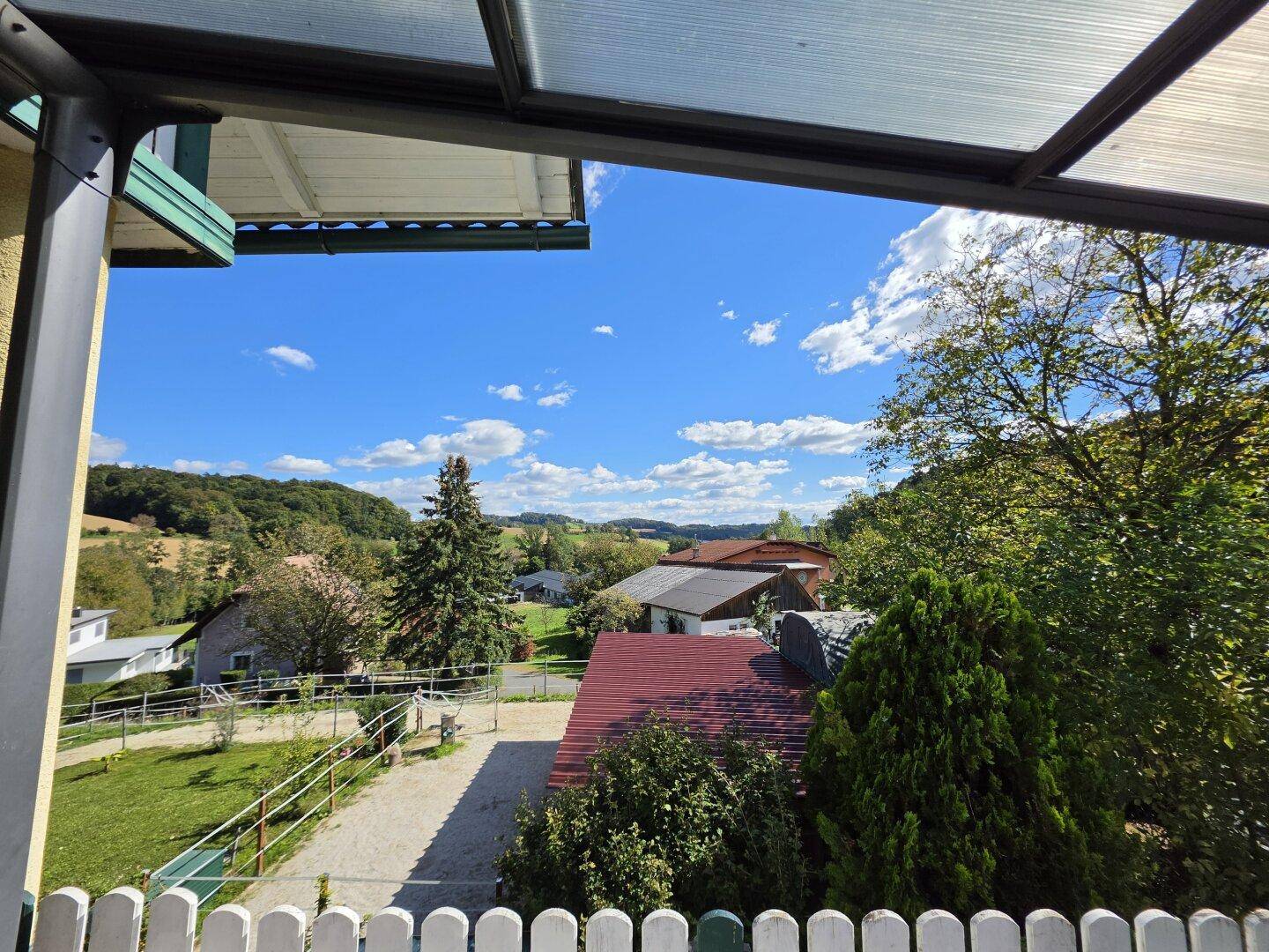 Panoramablick von der Terrasse auf die umliegende ländliche Bebauung und Natur.