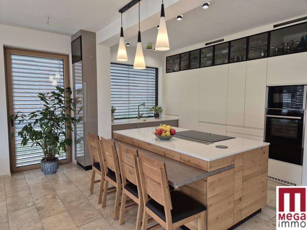 Moderne Einbauküche mit Kochinsel, integrierten Geräten und hellem Holzdekor.