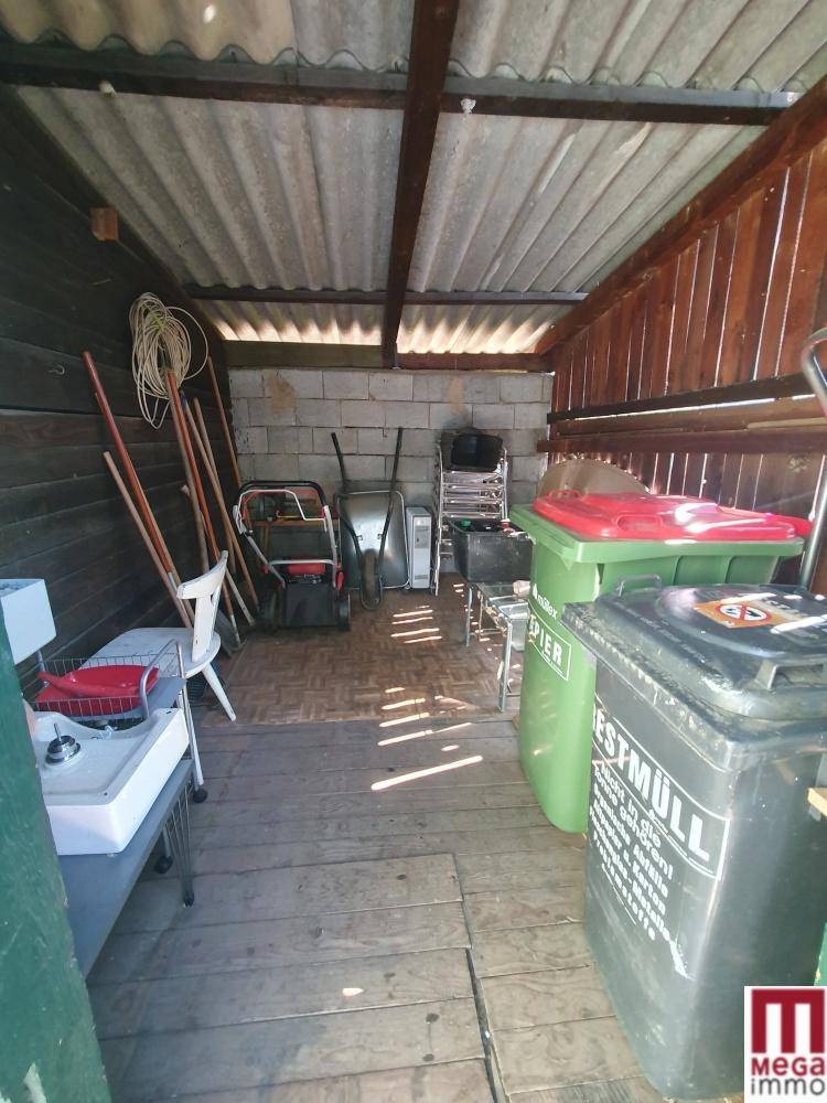 Lagerraum in einem Schuppen mit Gartengeräten und Mülltonnen.