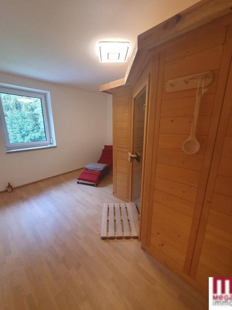 Raum mit integrierter Holzsauna und Liegefläche, ideal für Entspannung und Wellness.