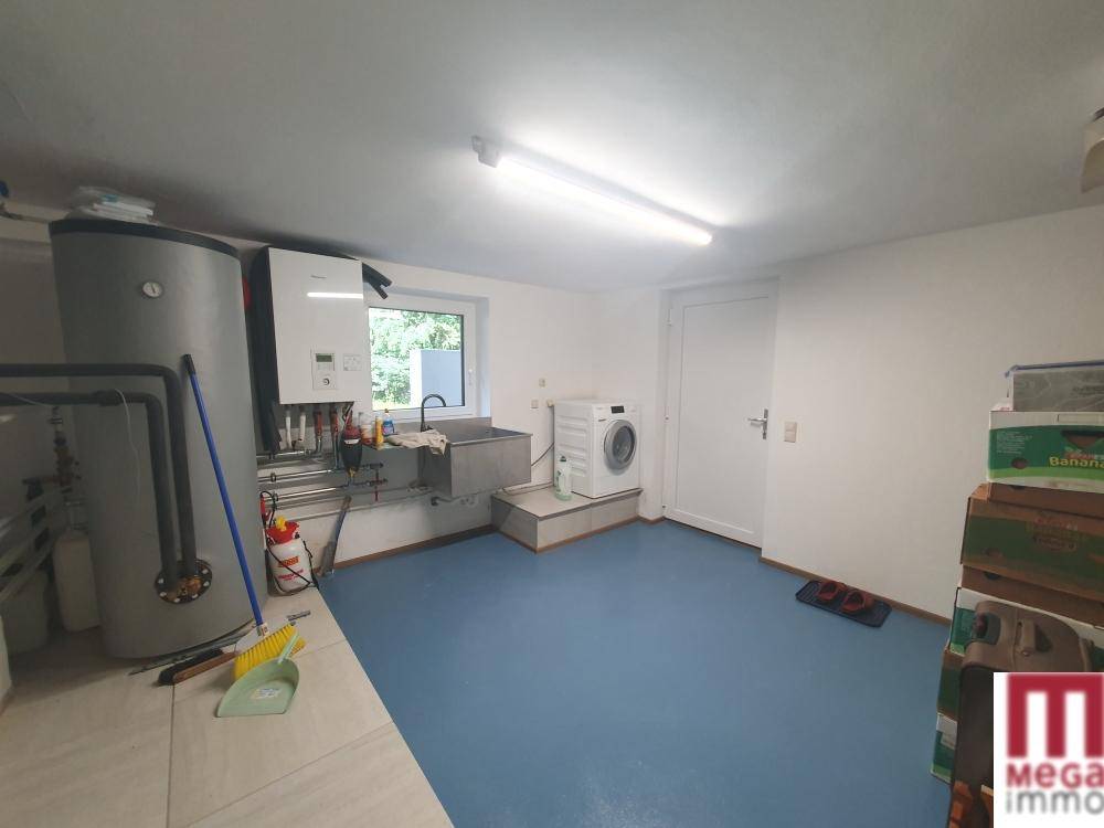 Praktischer Hauswirtschaftsraum mit Waschmaschine, Boiler und Waschbecken, funktional eingerichtet.