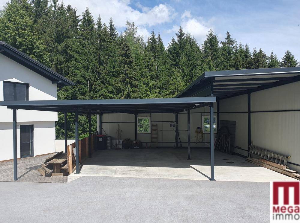 Modernes Gebäude mit großem Carport und angrenzendem Lagerbereich.