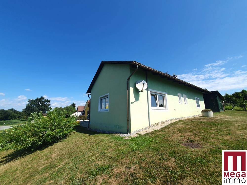Seitenansicht des Hauses mit grünem Anstrich und Satellitenschüssel.