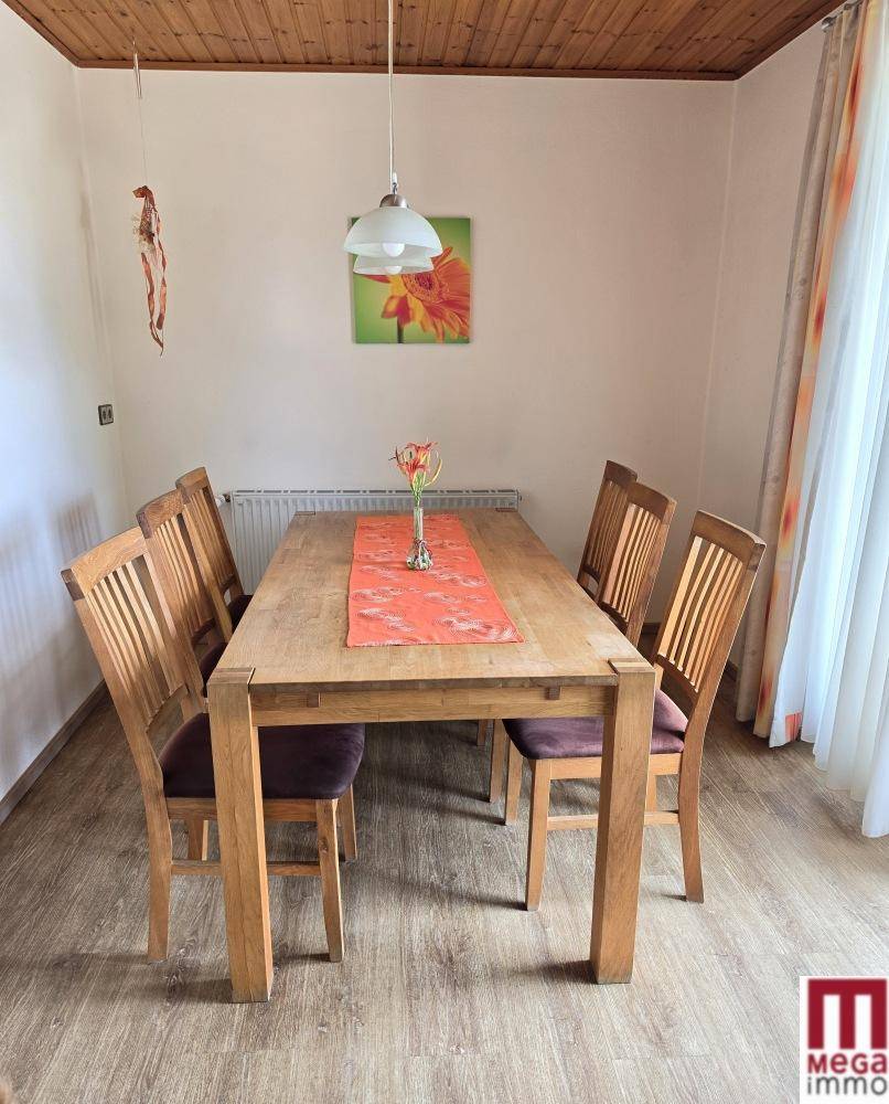Gemütlicher Essbereich mit Holztisch und Stühlen, ideal für Familienmahlzeiten.