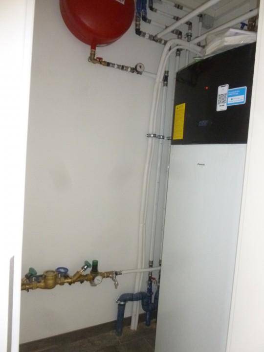 Hauswirtschaftsraum mit moderner Wärmepumpe und Installationen für die Haustechnik.