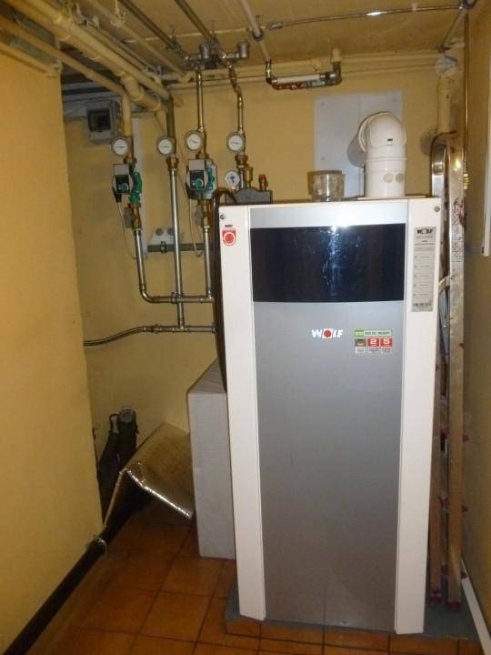 Heizungsraum mit moderner Heizanlage und sichtbaren Rohrleitungen.