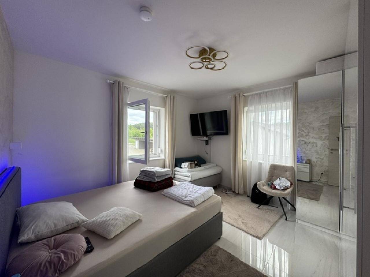 Gemütliches Schlafzimmer mit Doppelbett, Spiegelschrank und Blick ins Grüne.