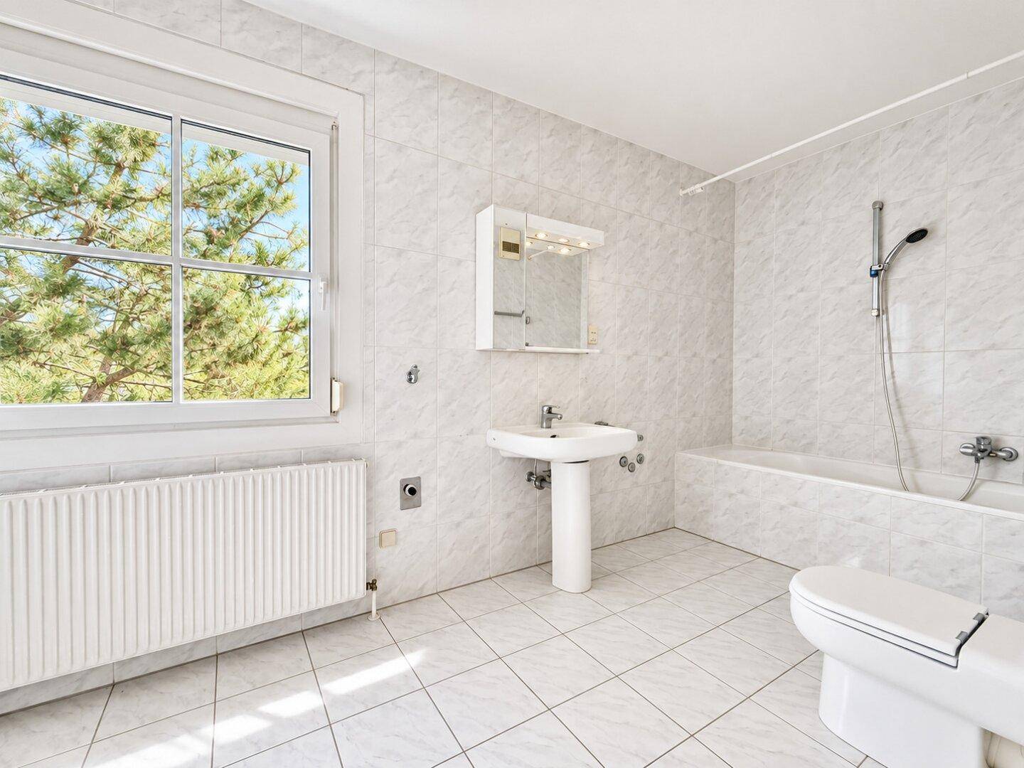 Badezimmer mit Wanne, Waschtisch, WC und Waschmaschinen-Anschluss