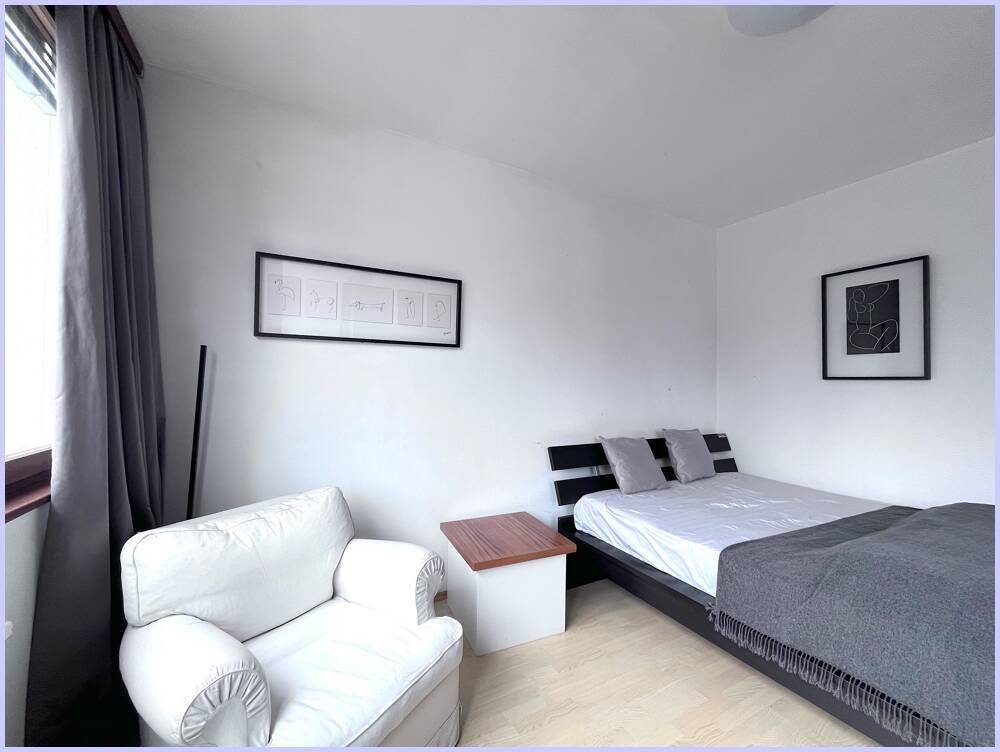 Gemütlicher Schlafbereich mit Einzelbett und Sessel, hell und funktional eingerichtet.