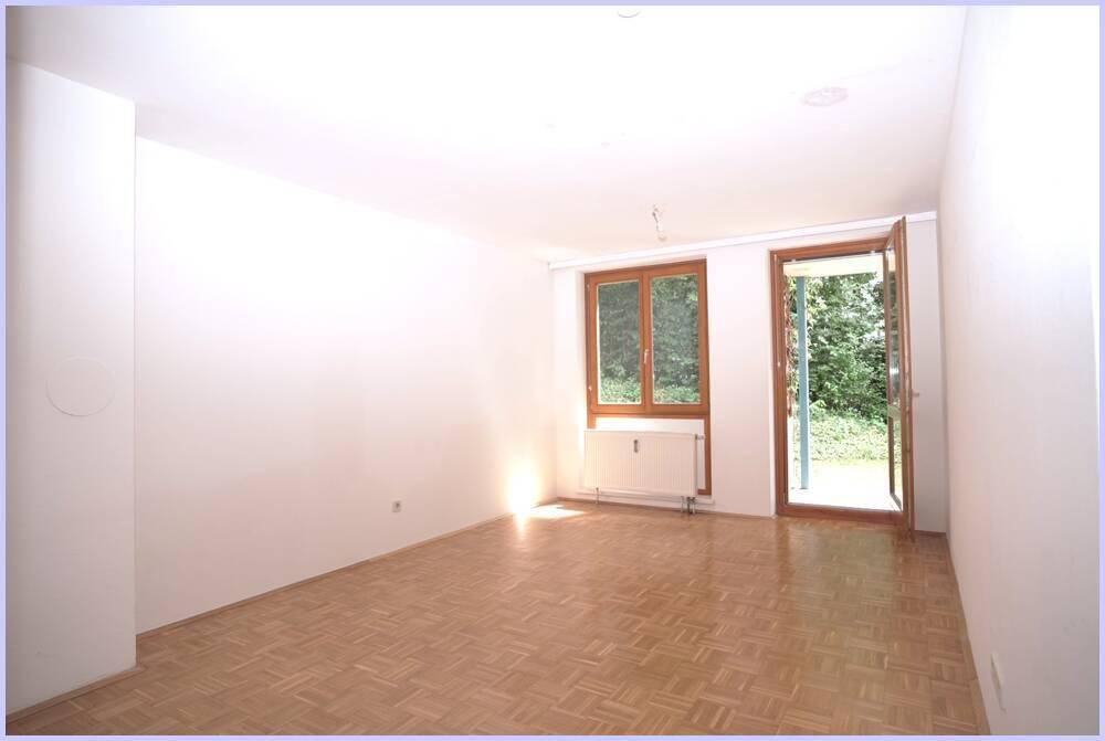 Heller Wohnraum mit Parkettboden und direktem Zugang zum Gartenbereich.