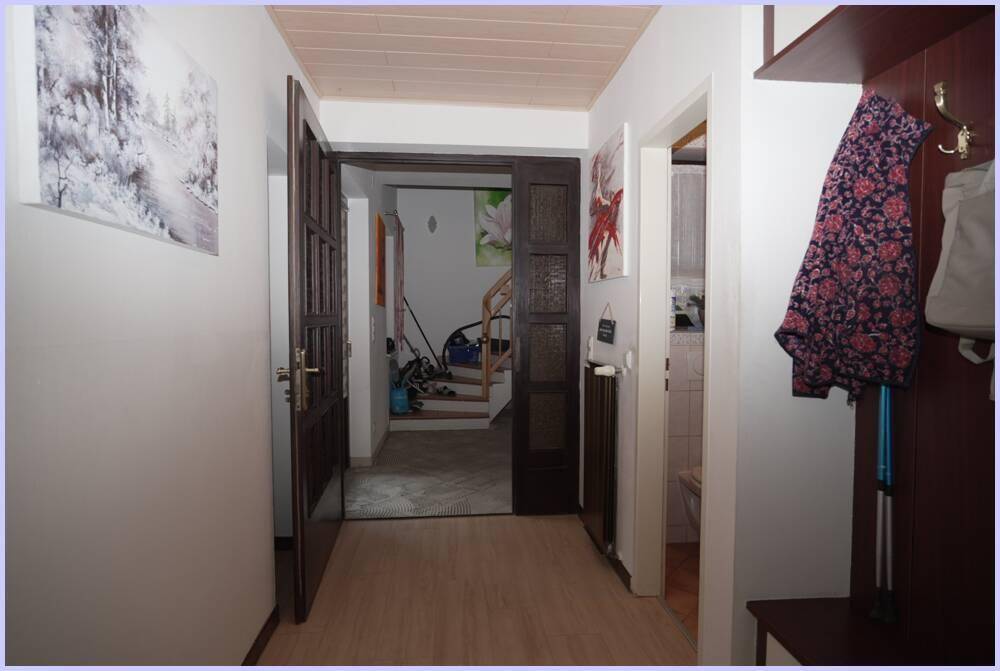 Gemütlicher Flur mit Garderobe, Holzboden und Zugang zu weiteren Räumen.