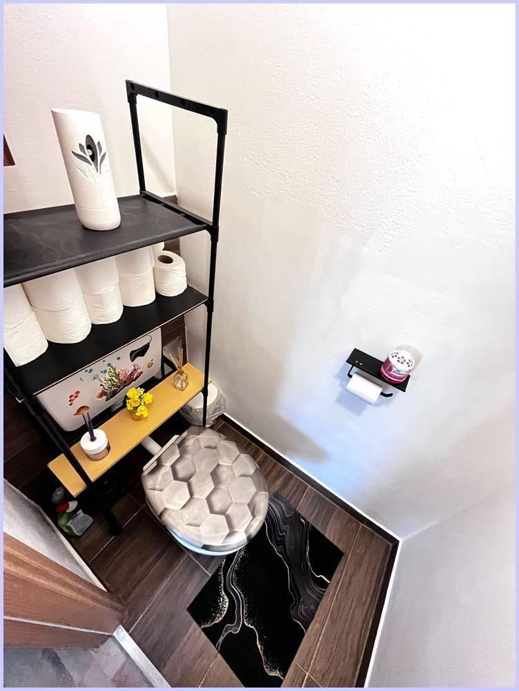 Separates WC mit Toilette und praktischem Regal für zusätzlichen Stauraum.