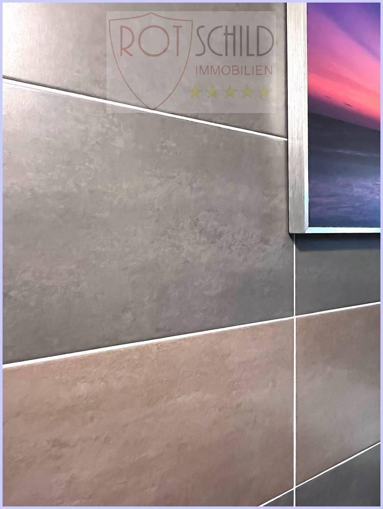 Nahaufnahme von modernen Wandfliesen in Grau- und Brauntönen mit geometrischem Muster.