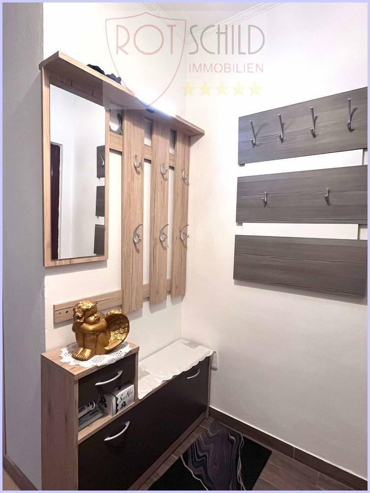 Eingangsbereich mit Garderobe, Spiegel und Schuhschrank, praktisch und funktional gestaltet.