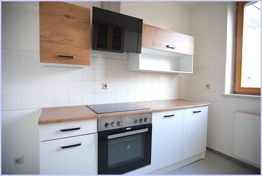 Nahaufnahme der modernen Küche mit Kochfeld, Backofen und Dunstabzugshaube.