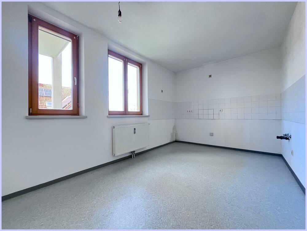 Leere Küche mit Fliesenwand und Anschlussmöglichkeiten für Geräte, bereit zur individuellen Gestaltung.