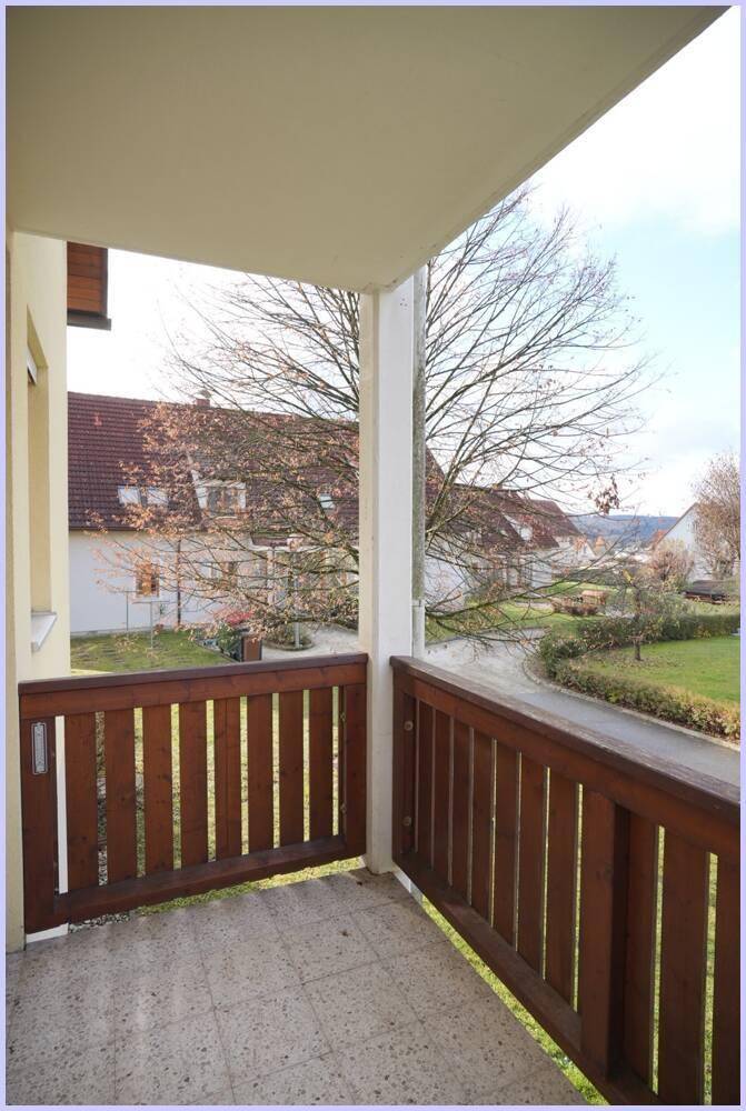 Kleiner Balkon mit Holzbalken und Blick ins Grüne, ideal zum Entspannen.