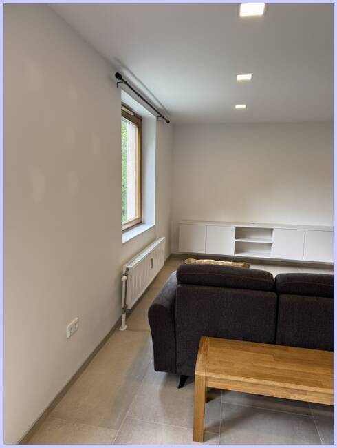 Heller Wohnbereich mit Fenster, Heizkörper und Blick nach draußen, ideal zum Entspannen.