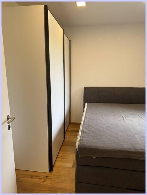 Schlafzimmer mit komfortablem Bett und praktischen weißen Einbauschränken für Stauraum.