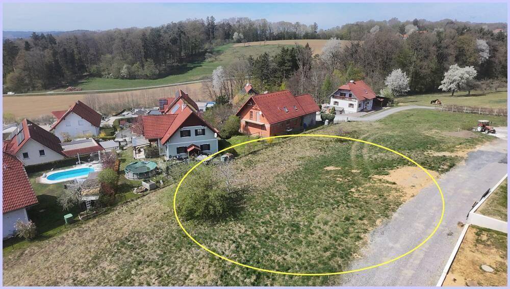 Weitläufige Luftaufnahme eines Baugrundstücks in ländlicher Umgebung mit angrenzenden Häusern und Pool.