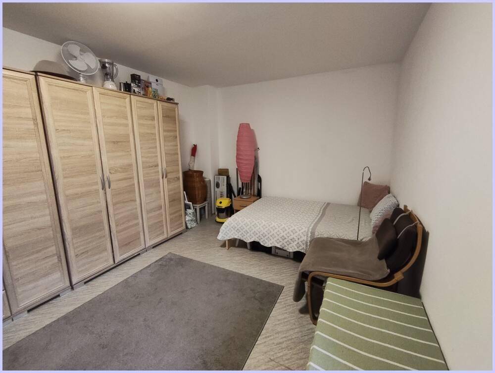 Schlafzimmer mit großem Kleiderschrank, Doppelbett und Teppichboden, bietet ausreichend Stauraum.