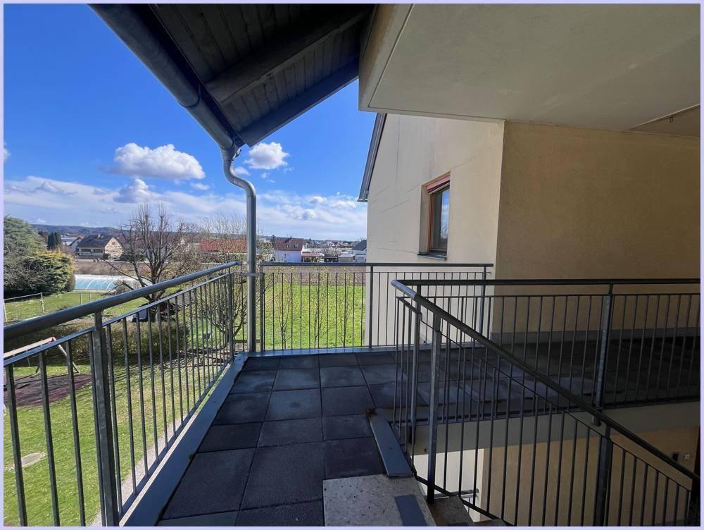 Balkon mit Fliesenboden und Metallgeländer, bietet einen weiten Blick auf die Umgebung und einen Pool.