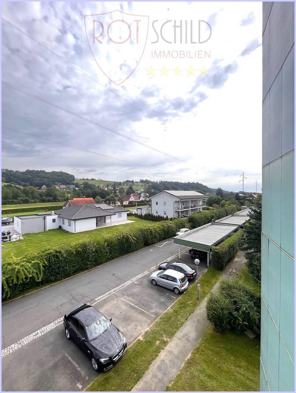 Weitläufiger Blick vom Balkon auf die umliegende Wohngegend und Parkplätze.