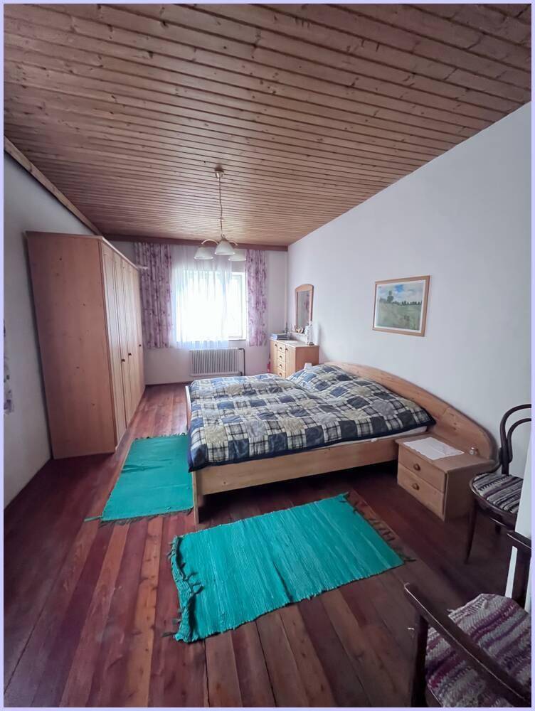 Gemütliches Schlafzimmer mit Holzboden, Holzdecke und einem Doppelbett, das zum Entspannen einlädt.