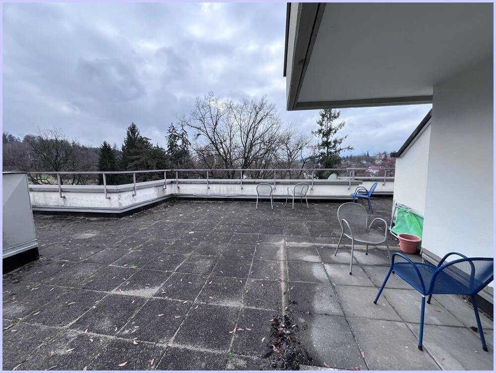 Geräumige Dachterrasse mit Fliesenboden und weitem Blick über die Umgebung.