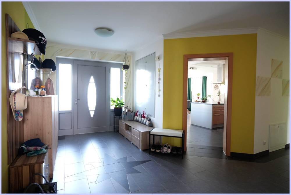 Geräumiger Eingangsbereich mit heller Tür, Garderobe und Blick in die Küche.