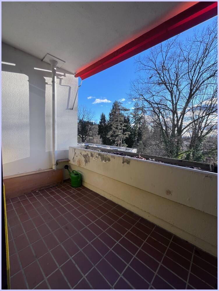 Balkon mit Fliesenboden und Blick ins Grüne, ideal für entspannte Stunden im Freien.