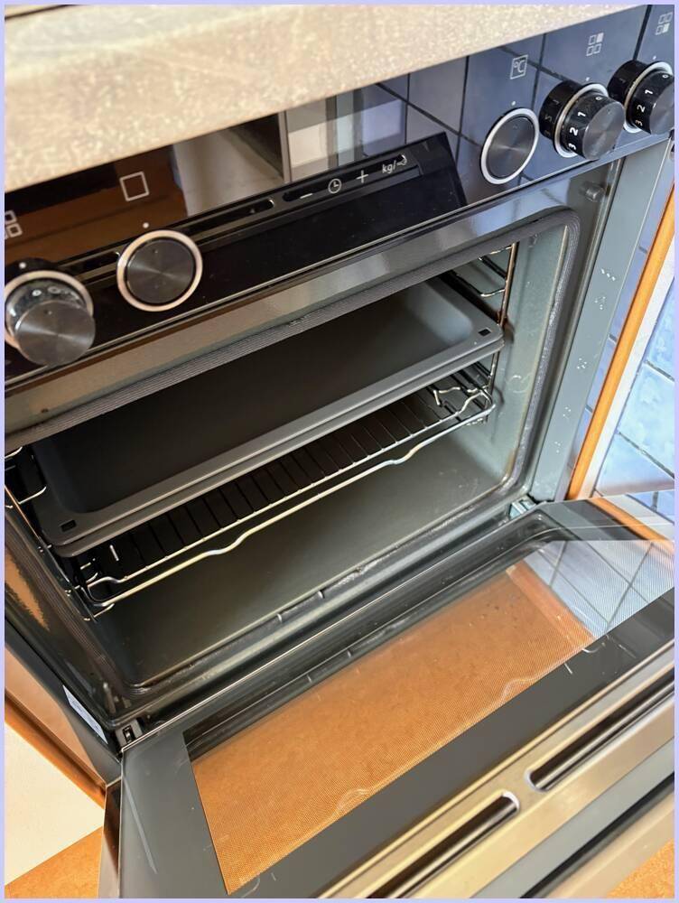 Eingebauter Backofen mit Bedienknöpfen und zwei Einschüben in einer funktionalen Küche.