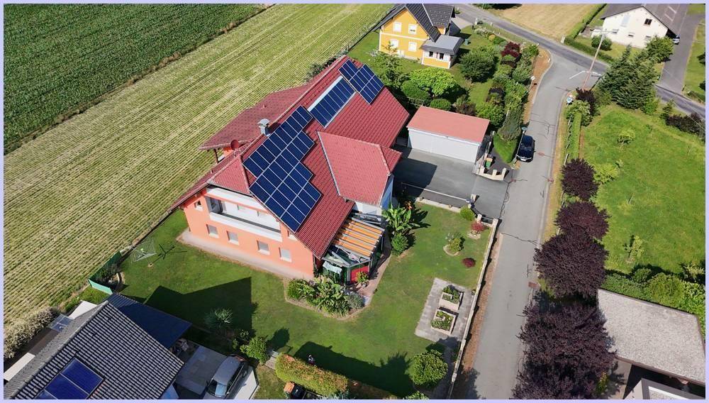 Luftaufnahme des Hauses mit Photovoltaikanlage, Garage und gepflegtem Vorgartenbereich.