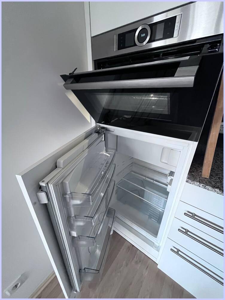 Integrierter Kühlschrank mit Gefrierfach, nahtlos in die Küchenzeile integriert.