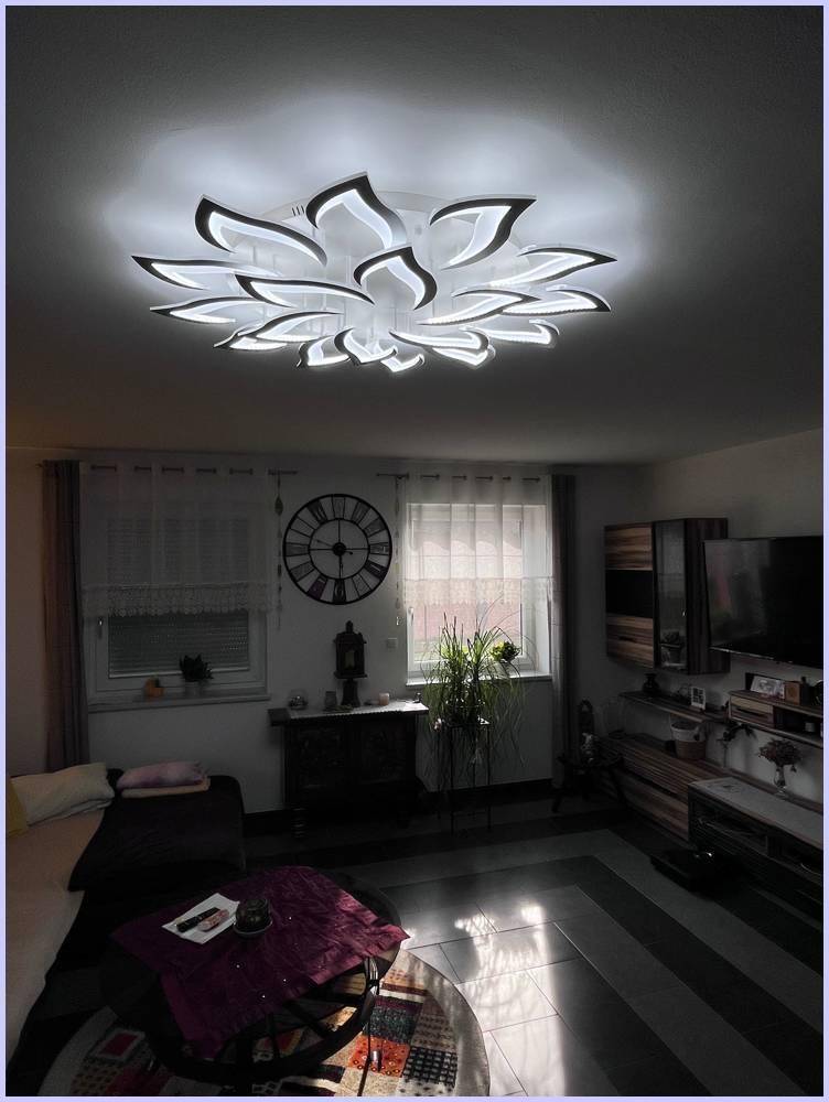 Gemütliches Wohnzimmer mit dekorativer Deckenleuchte, Sofa und Fernsehmöbeln.