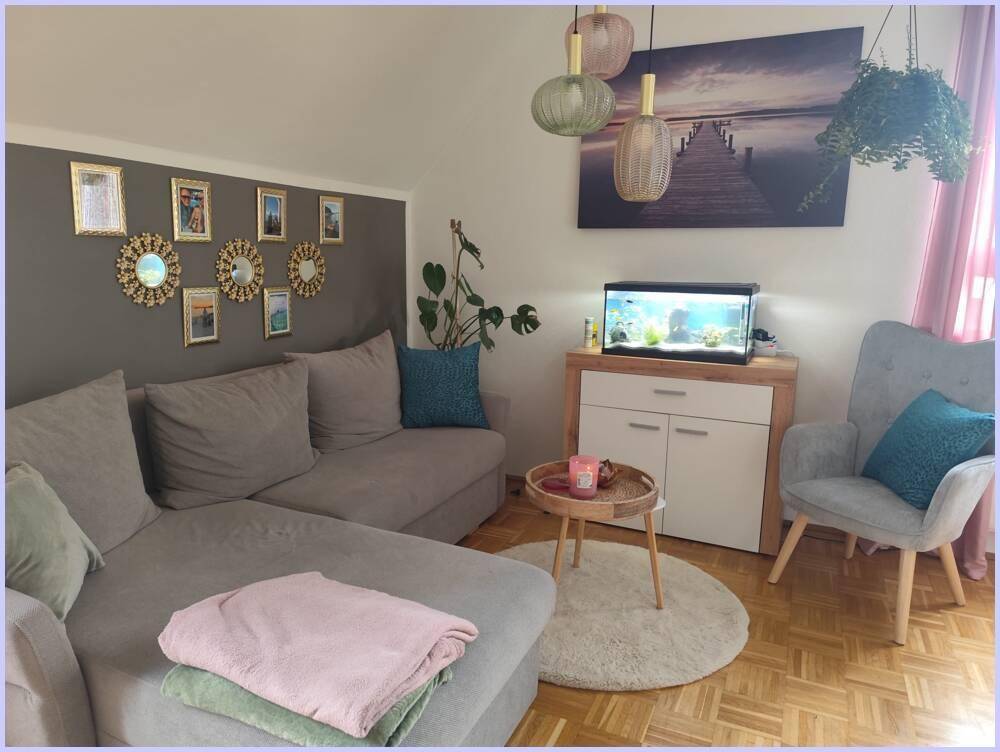 Gemütliches Wohnzimmer mit Sofa, Aquarium und moderner Dekoration.