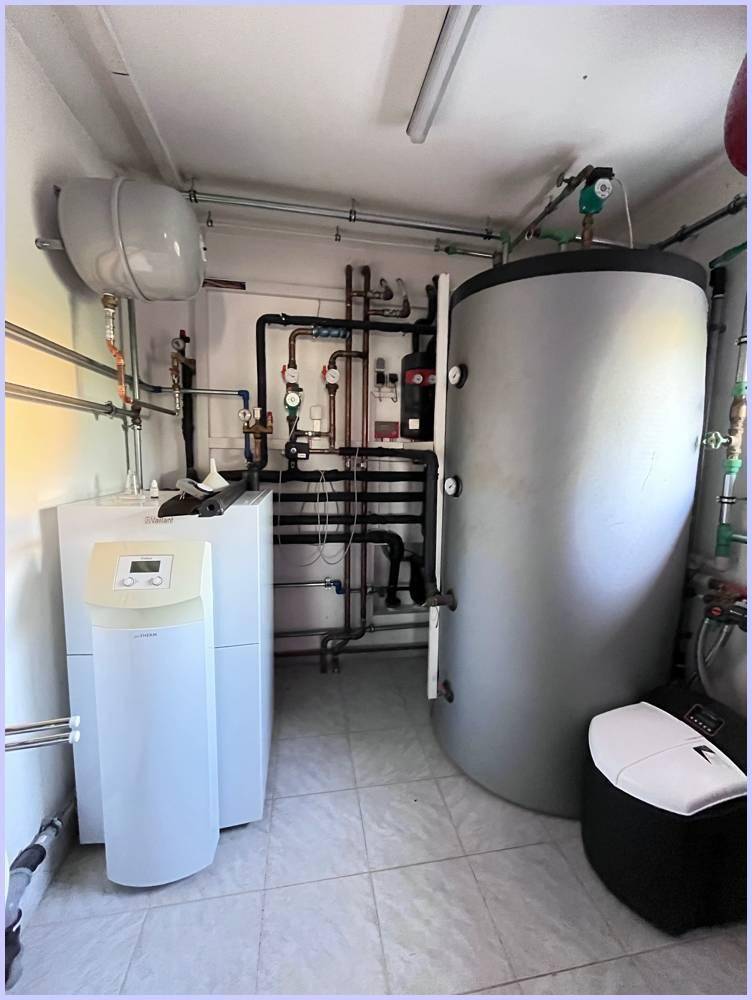 Heizungsraum mit moderner Heizungsanlage und Warmwasserspeicher.