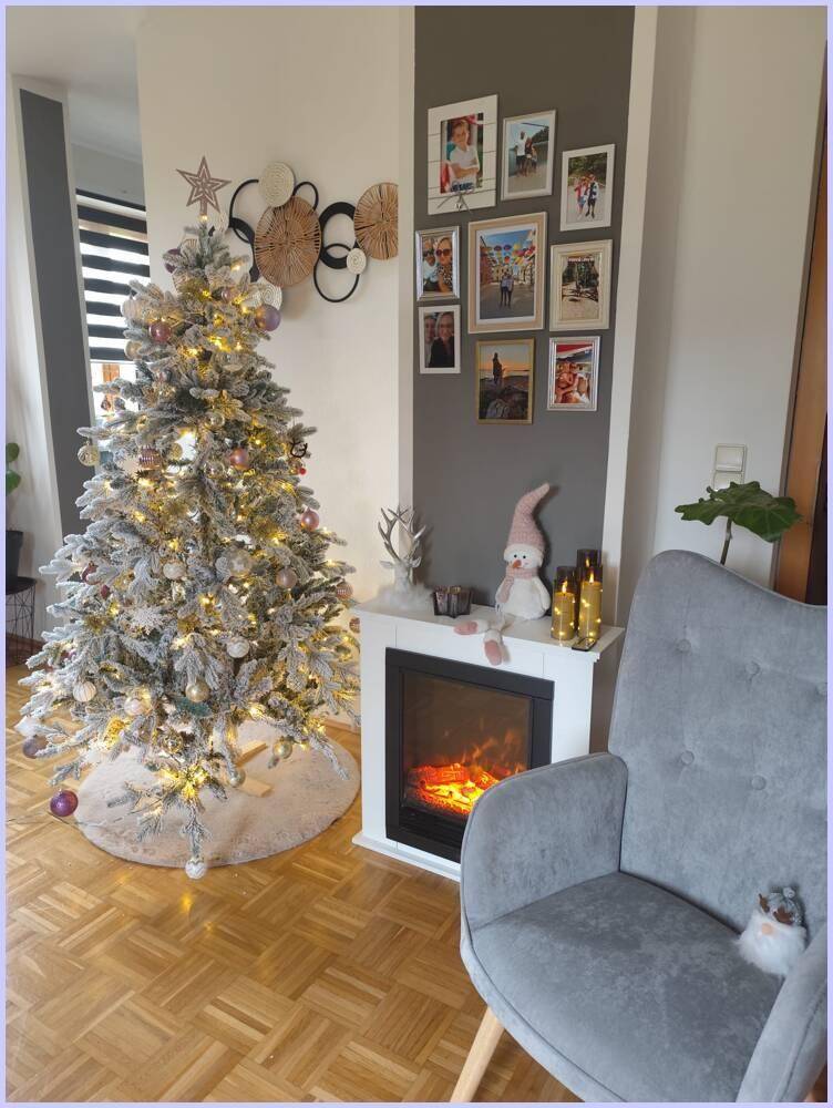 Festlich dekoriertes Wohnzimmer mit Weihnachtsbaum und elektrischem Kamin.