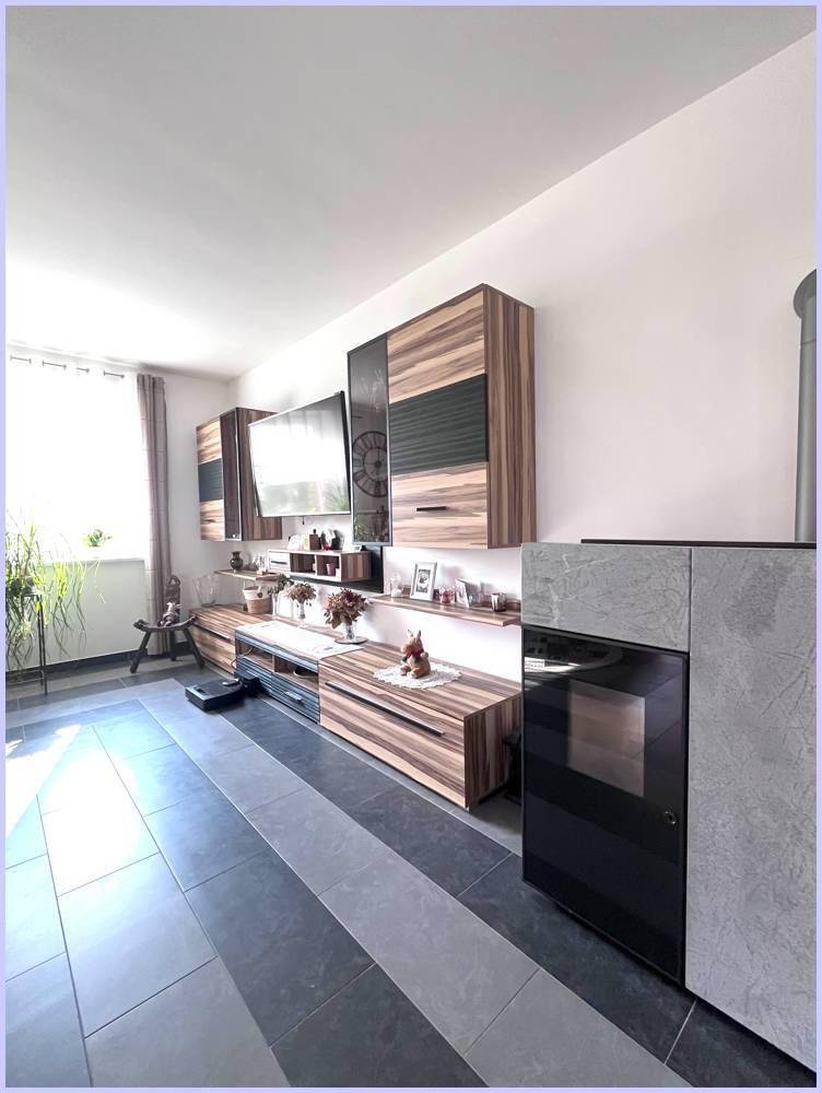 Modernes Wohnzimmer mit Medieneinheit, Kaminofen und großen Fenstern für viel Tageslicht.