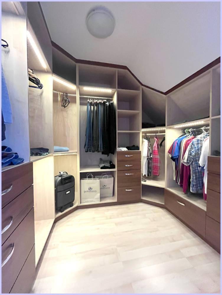 Begehbarer Kleiderschrank mit maßgefertigten Regalen, Schubladen und Beleuchtung.