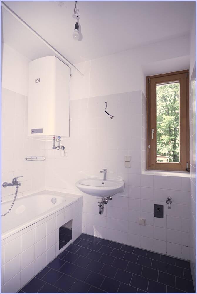 Helles Badezimmer mit Badewanne, Waschbecken und Fenster, ausgestattet mit Boiler.