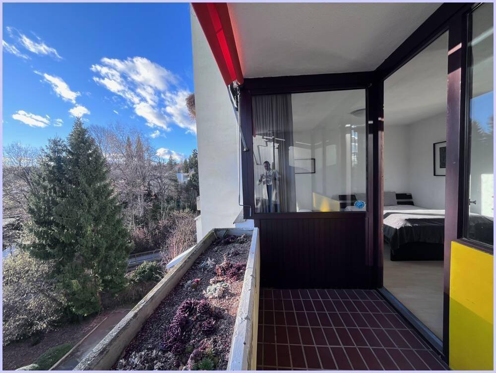 Balkon mit Pflanzkübeln und weitem Blick ins Grüne, direkt vom Wohnbereich zugänglich.