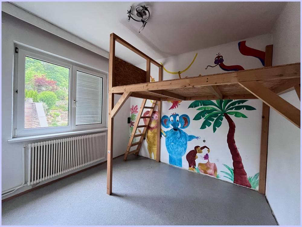 Kinderzimmer mit Hochbettkonstruktion aus Holz und farbenfrohen Wandmalereien im Dschungel-Stil.