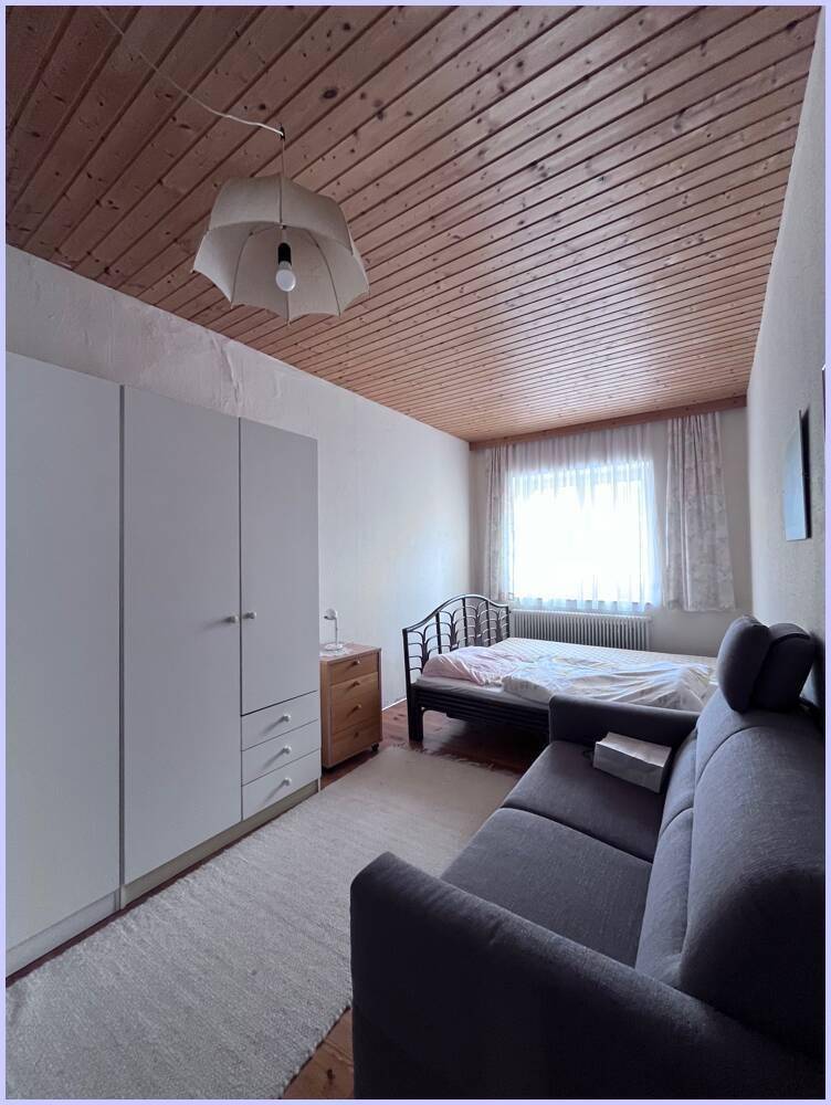 Schlafzimmer mit Teppichboden, Holzdecke und einem Kleiderschrank, der viel Stauraum bietet.