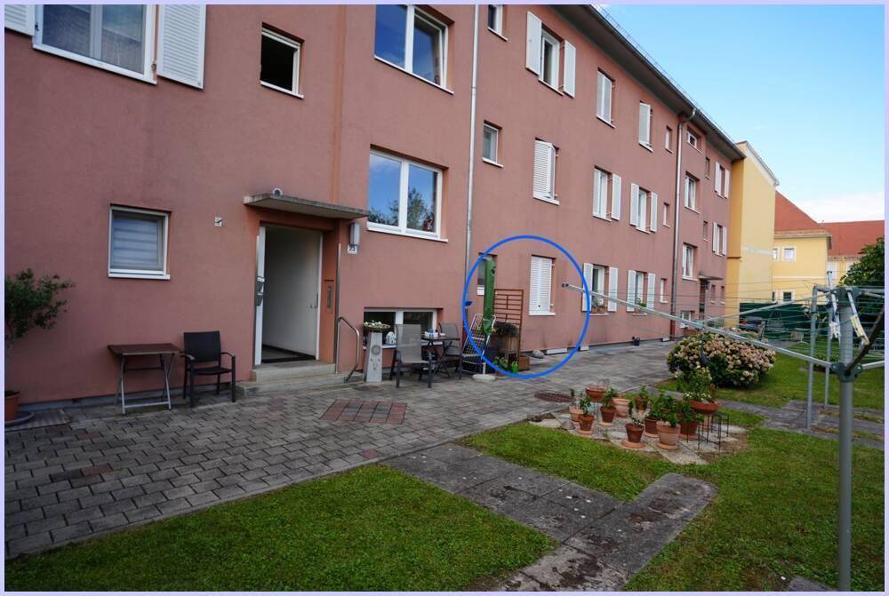 Außenbereich mit Terrasse, Sitzgelegenheiten und Blick auf die Gebäudefassade.