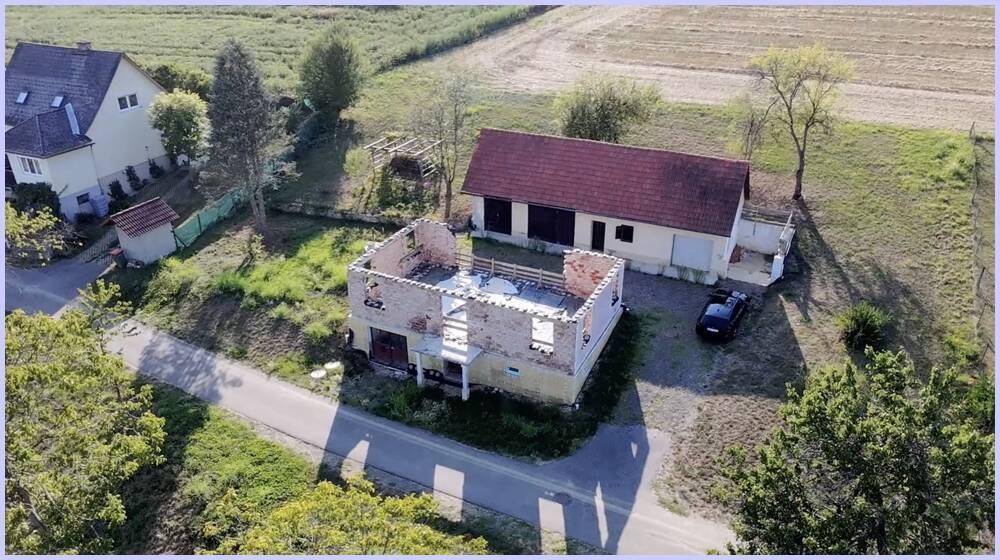 Luftaufnahme des Grundstücks mit einem teilweise abgerissenen Gebäude und einem weiteren Haus in ländlicher Umgebung.