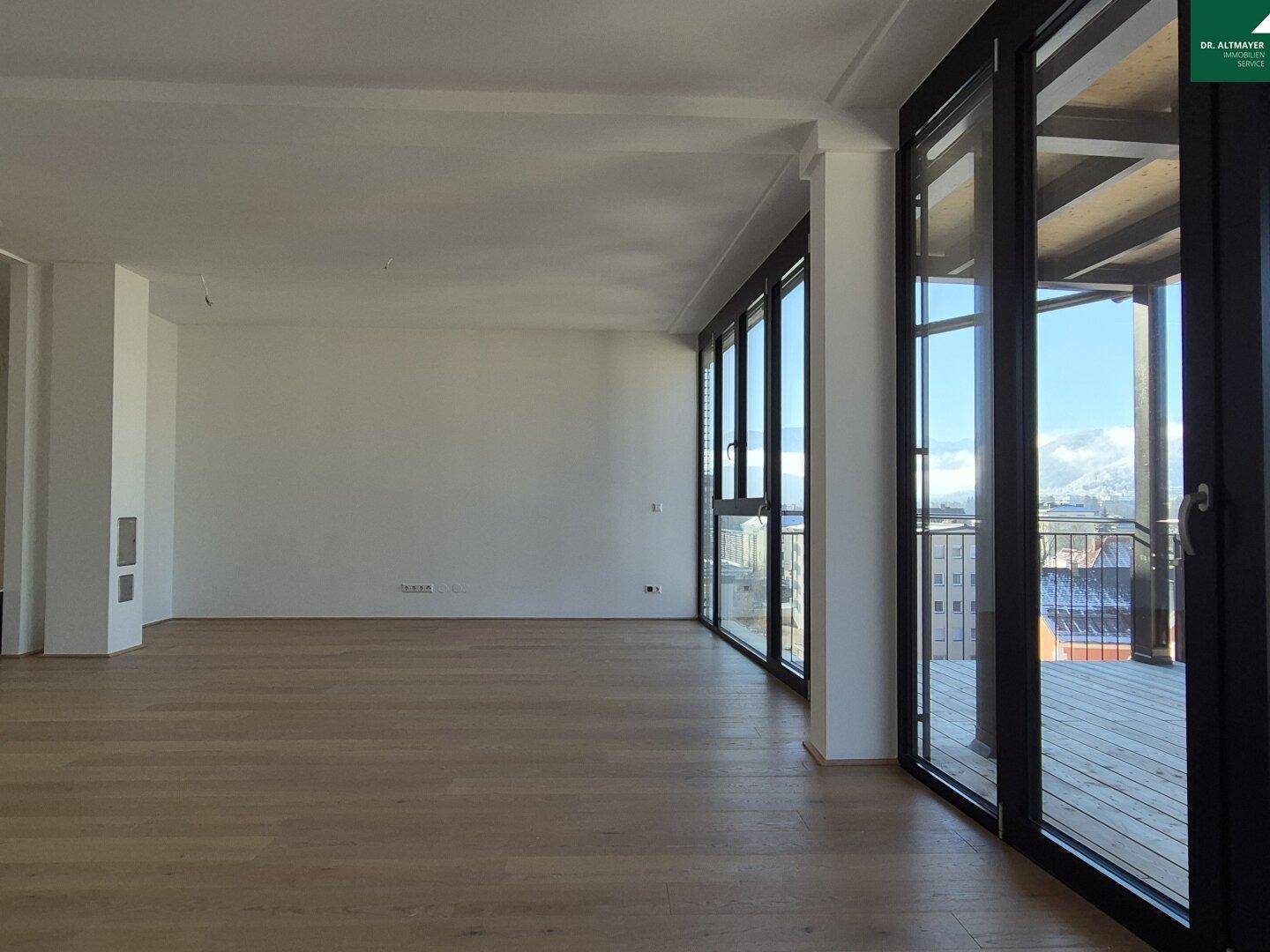 Geräumiges, helles Zimmer mit Holzboden und Zugang zu einer großen Terrasse.