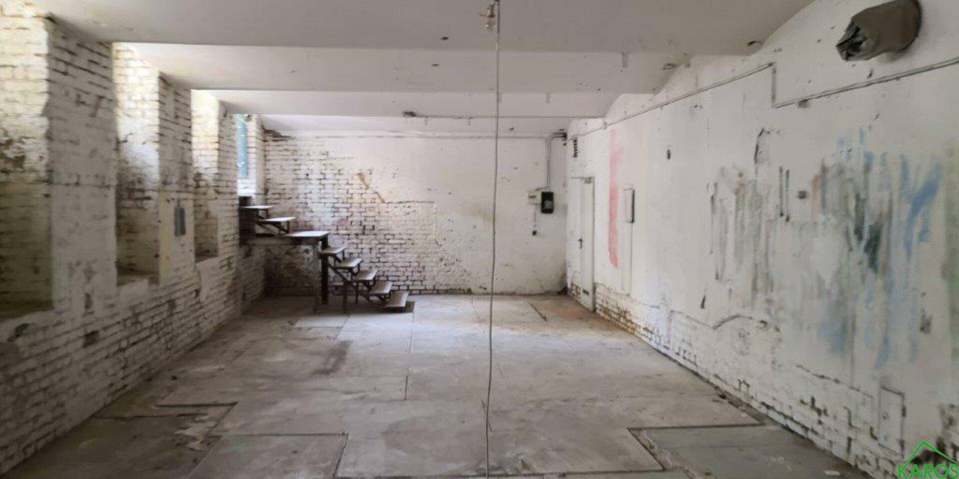 Großer, unrenovierter Kellerraum mit unverputzten Ziegelwänden und Betonboden, ideal für Lagerung oder Ausbau.