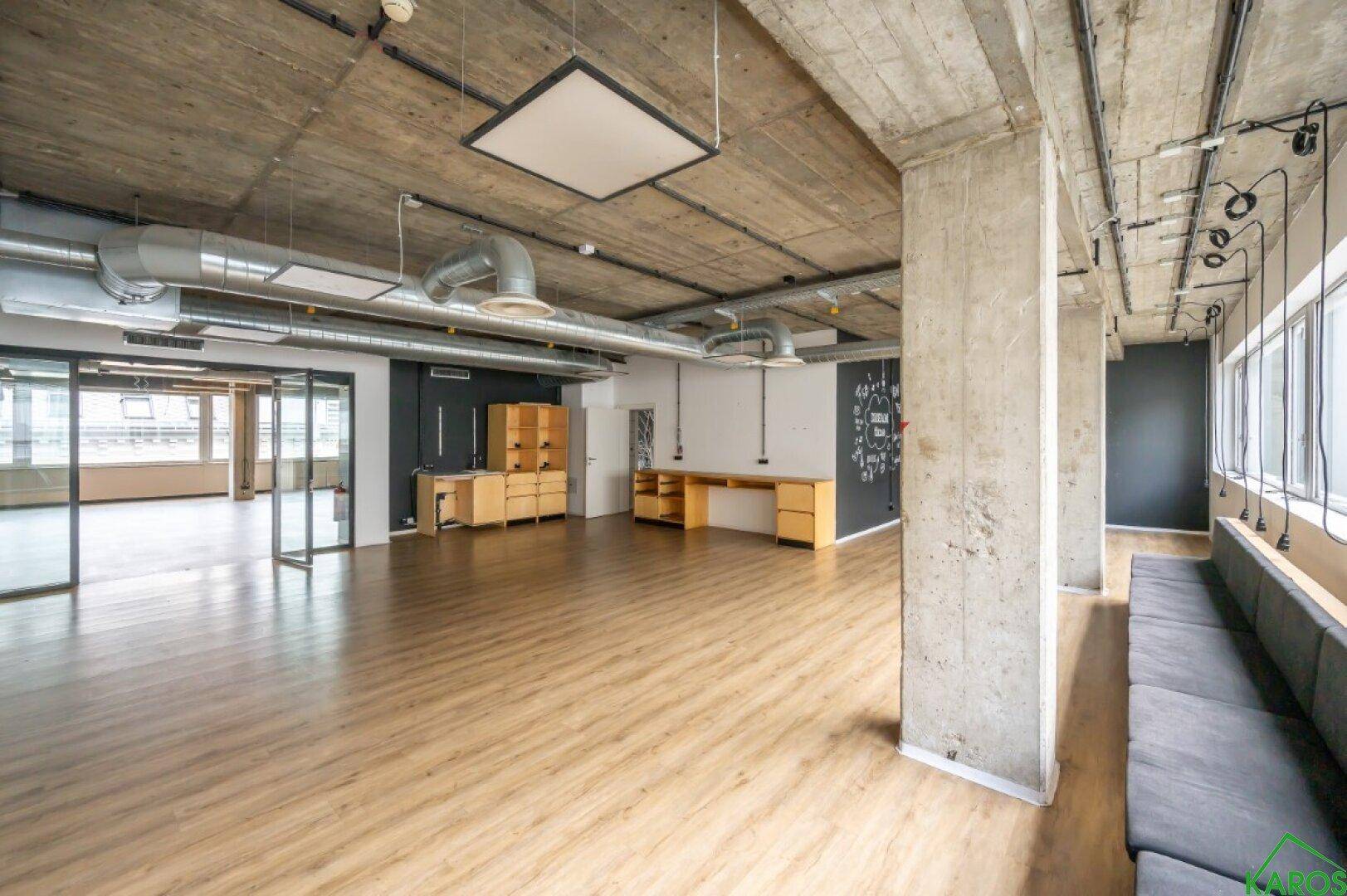 Geräumiges Büro mit Holzboden, freiliegenden Decken und integrierten Holzmöbeln.